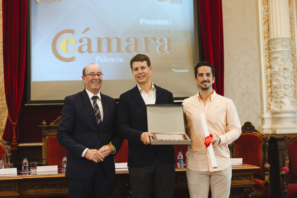 Tres hombres posando con premios en un evento de la Cámara de Comercio de Palencia