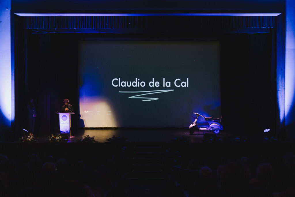 Claudio de la Cal recibiendo un premio en un escenario iluminado