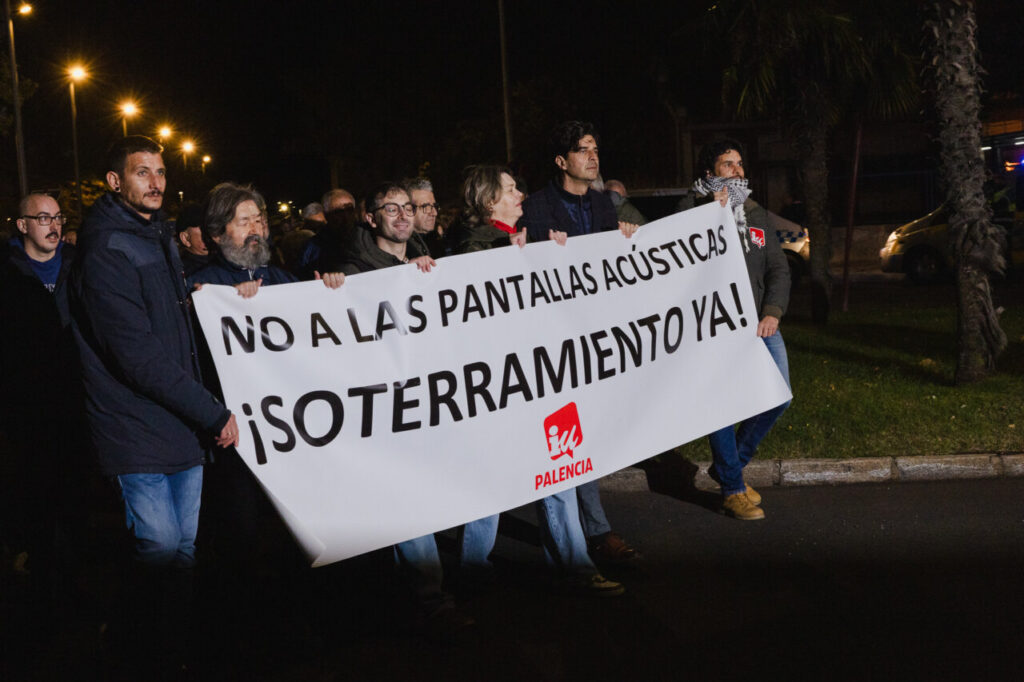 Manifestantes sosteniendo un cartel en la noche en Palencia
