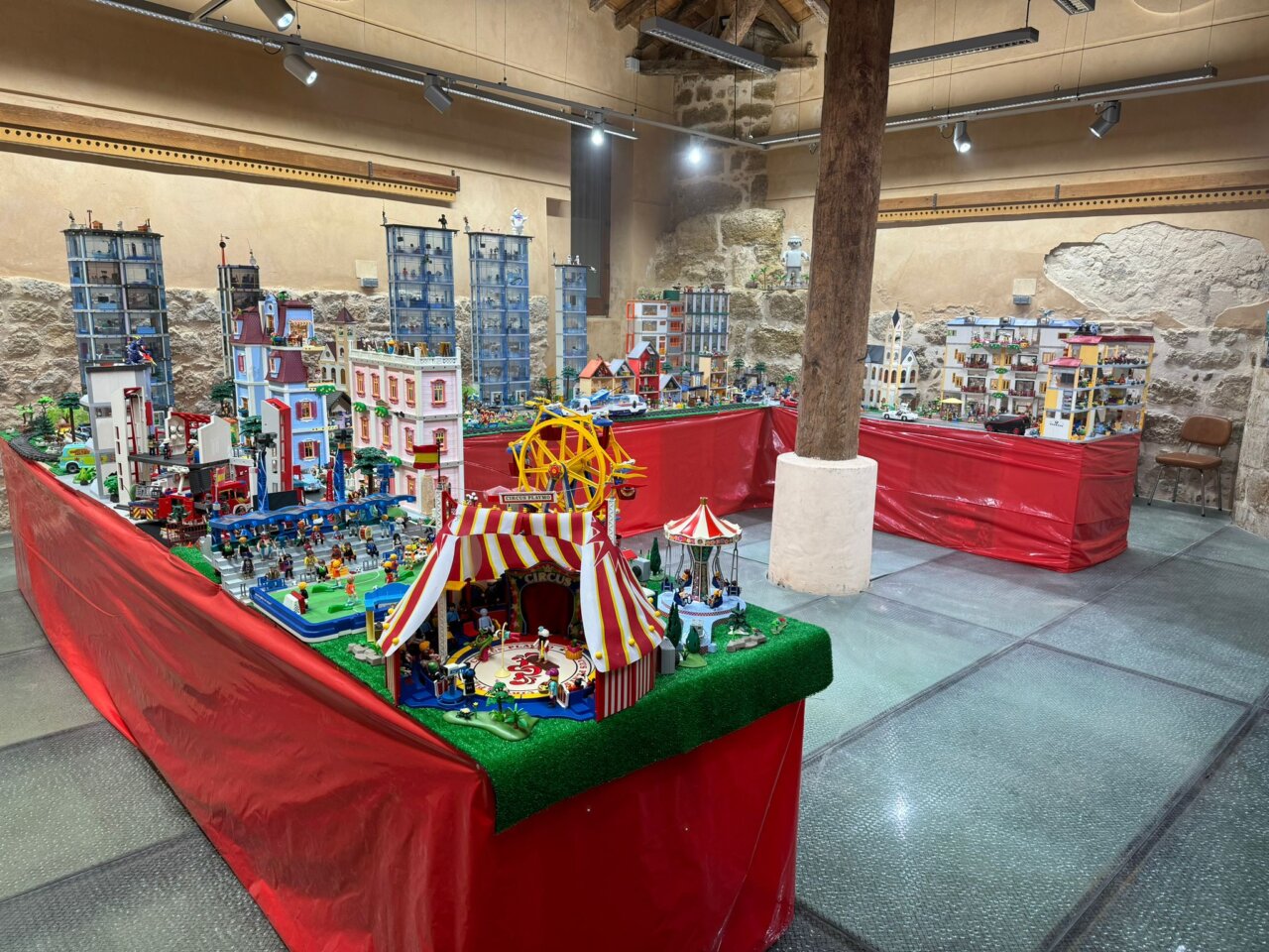 Diorama de Playmobil en exposición con edificios y feria