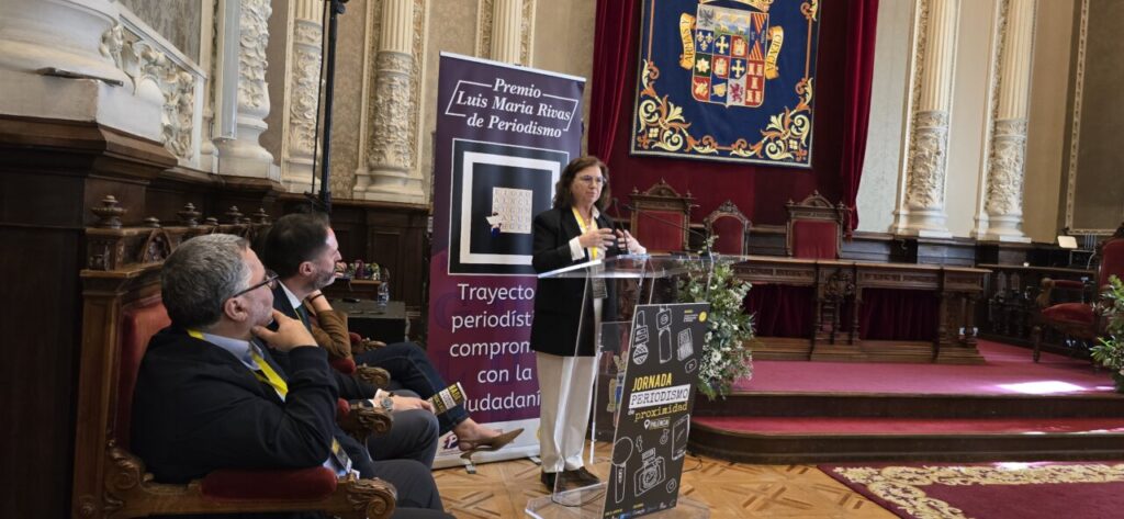 Mujer hablando en un evento sobre periodismo local en Palencia