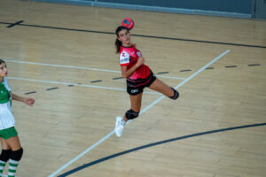 Jugadora de balonmano lanzando el balón en un partido