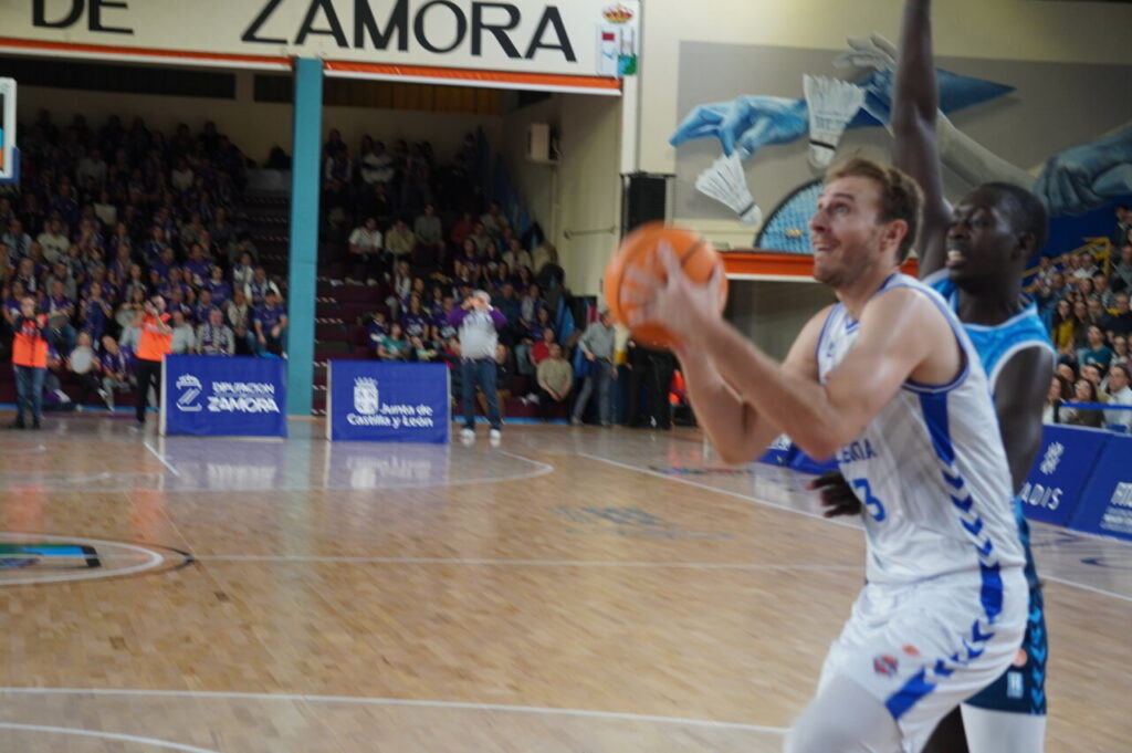 Jugador lanzando a canasta en un partido de baloncesto en Zamora.