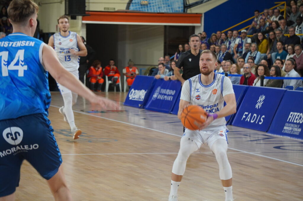 Jugador del equipo de baloncesto de Palencia lanzando a canasta durante un partido