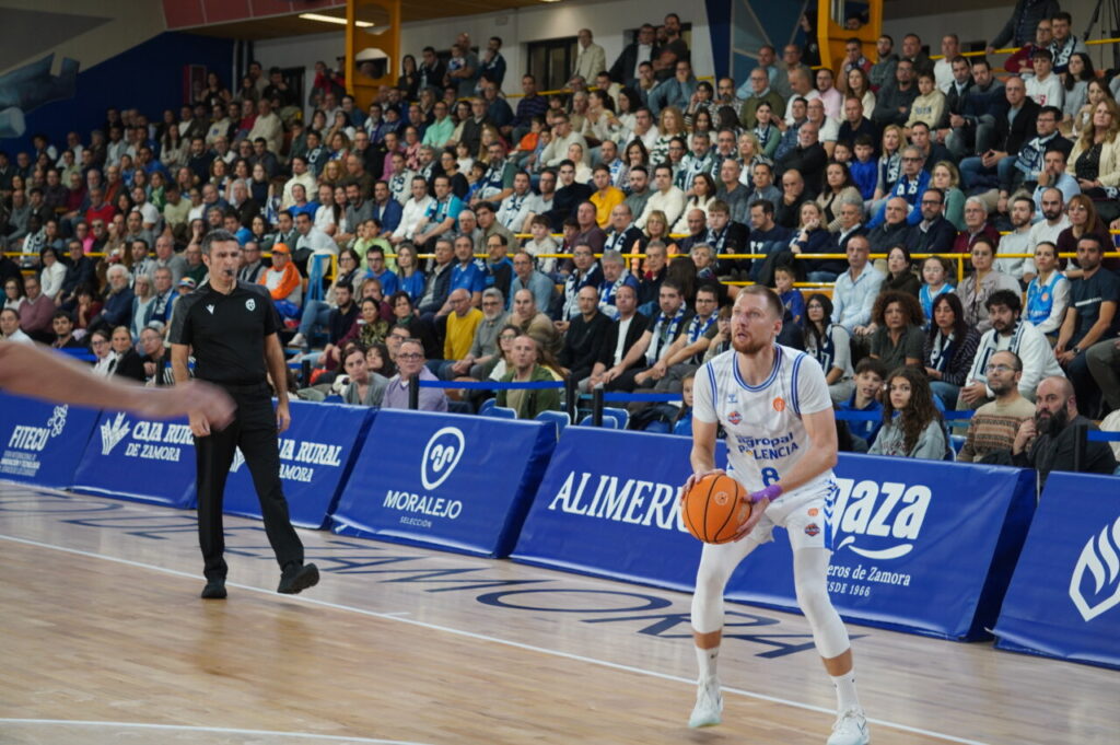 Jugador del equipo de baloncesto de Palencia lanzando a canasta en un partido