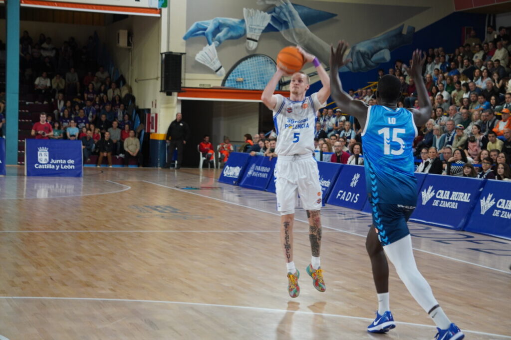 Jugador lanzando balón en partido de baloncesto entre Zamora y Palencia