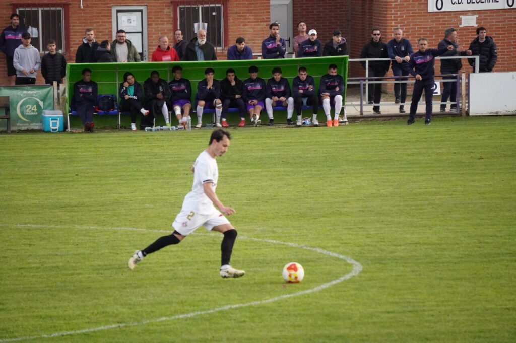 Jugador del CD Becerril ejecutando un tiro en un partido de fútbol.
