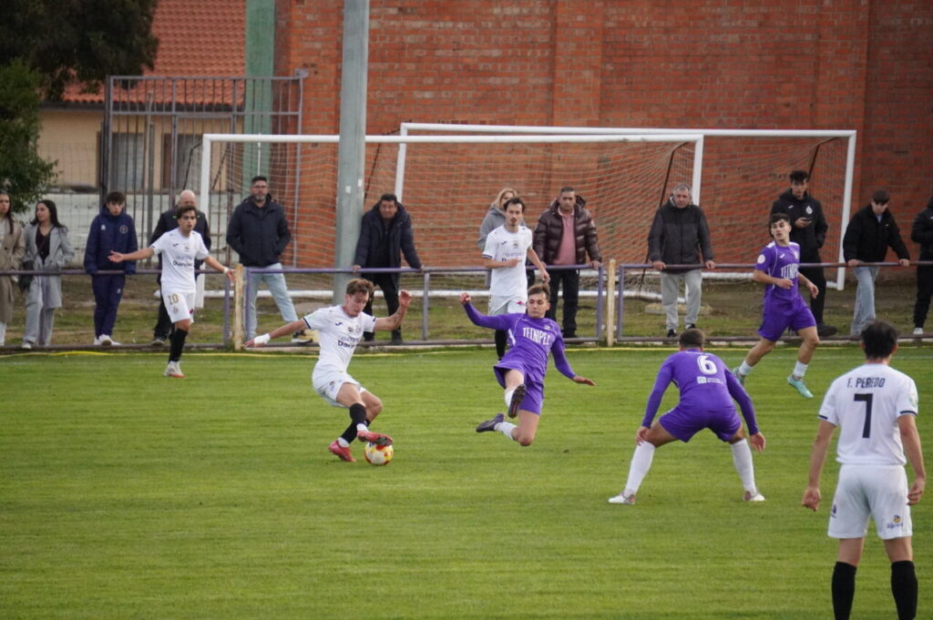 Jugadores del CD Becerril y Palencia Cristo Atlético en un partido de fútbol.