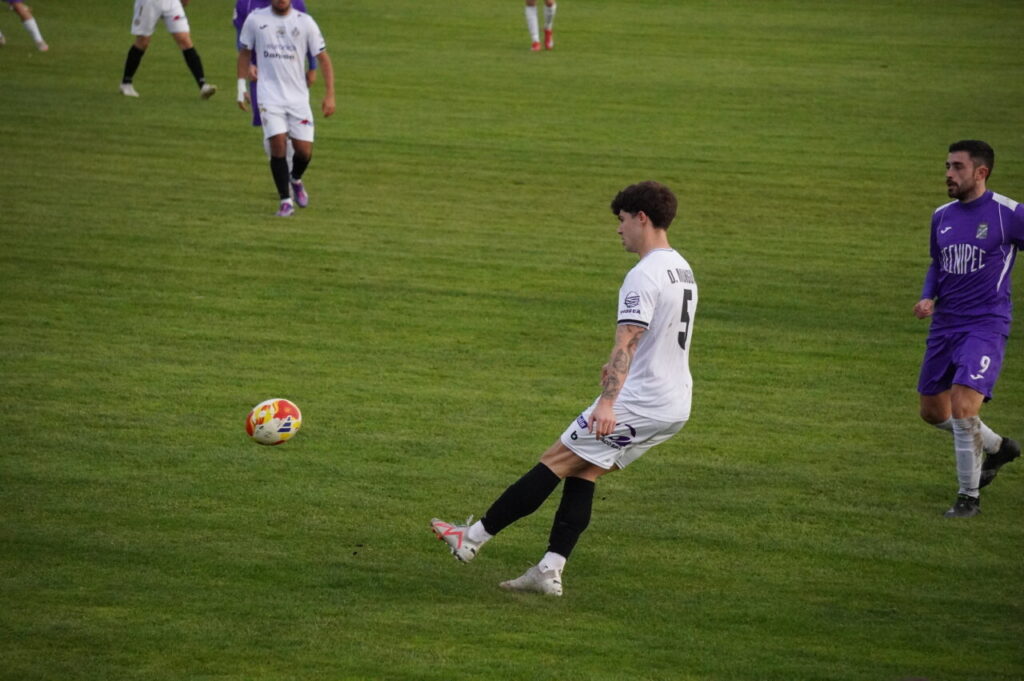 Jugador del Becerril controla el balón en un partido de fútbol