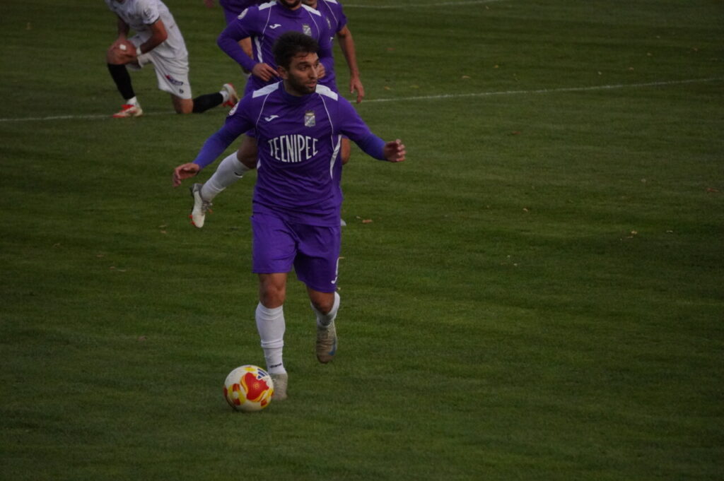 Jugador del CD Becerril corriendo con el balón en un partido de fútbol