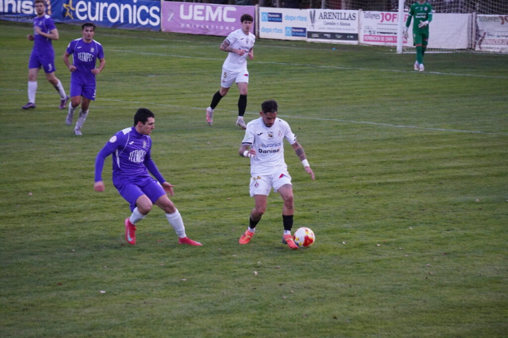 Jugadores del CD Becerril y Palencia Cristo Atlético en un partido de fútbol.