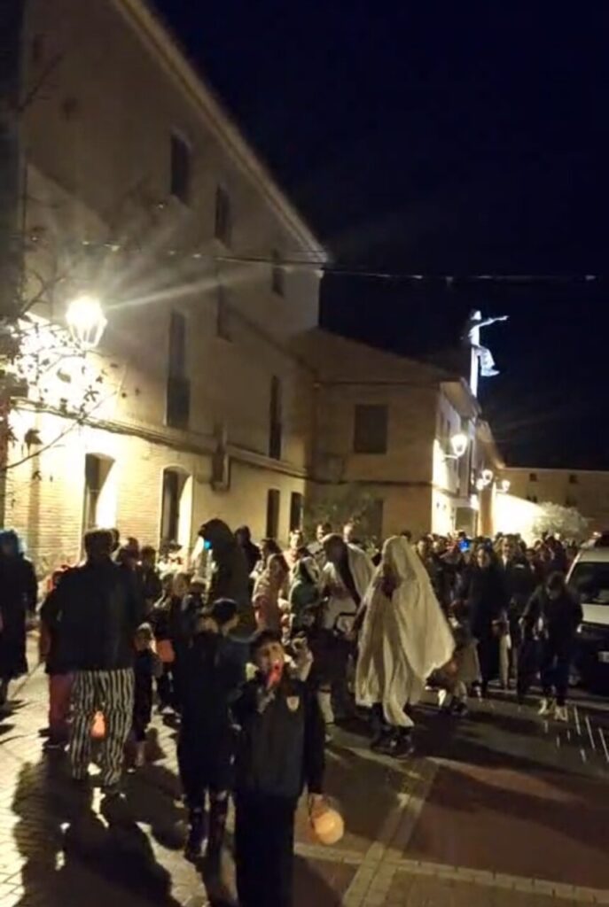 Niños y adultos disfrazados en las calles de Husillos durante Halloween