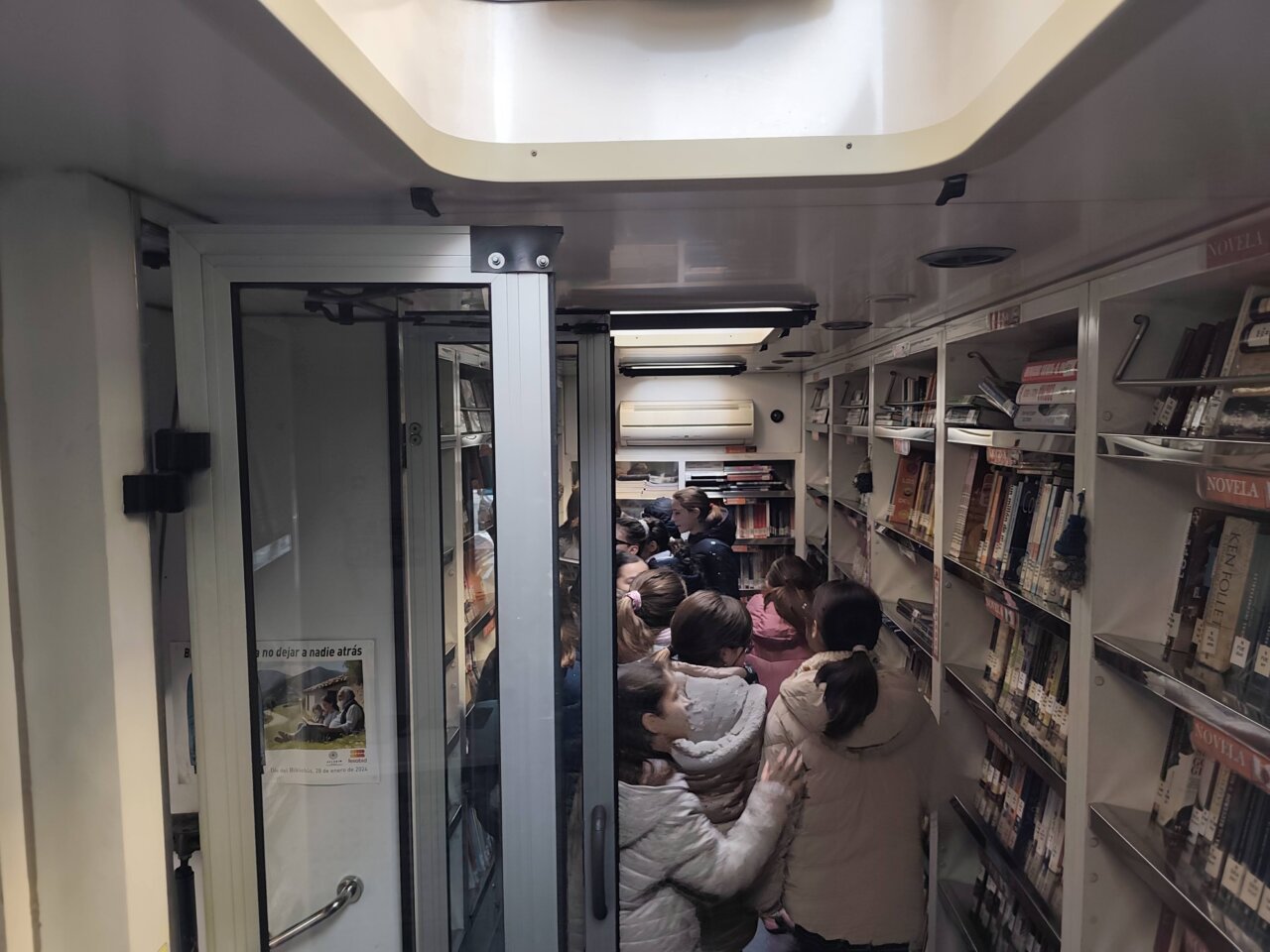Interior de un bibliobús con niños explorando libros