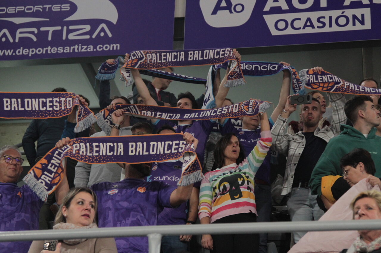 Aficionados sosteniendo bufandas de baloncesto en un partido