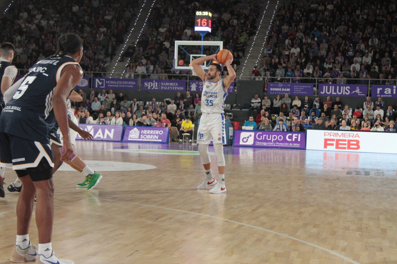 Jugador del Agropal Palencia lanzando el balón en un partido de baloncesto.