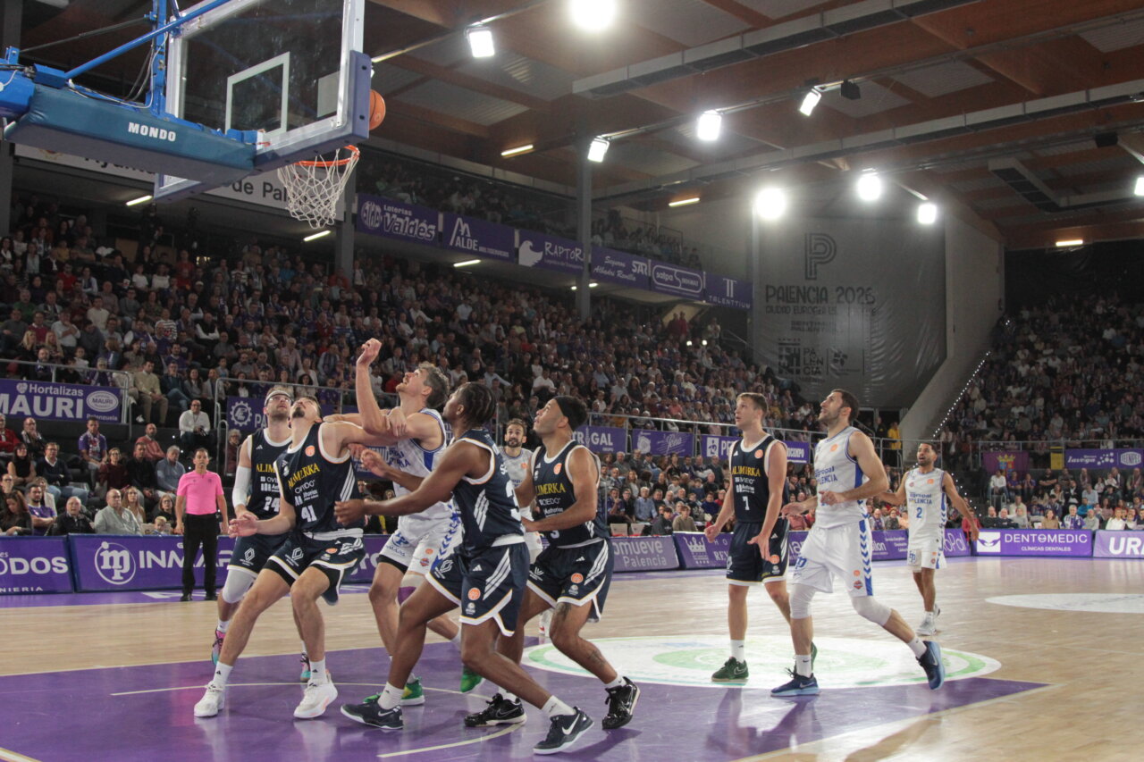 Jugadores de baloncesto compiten en un partido entre Palencia y Oviedo.