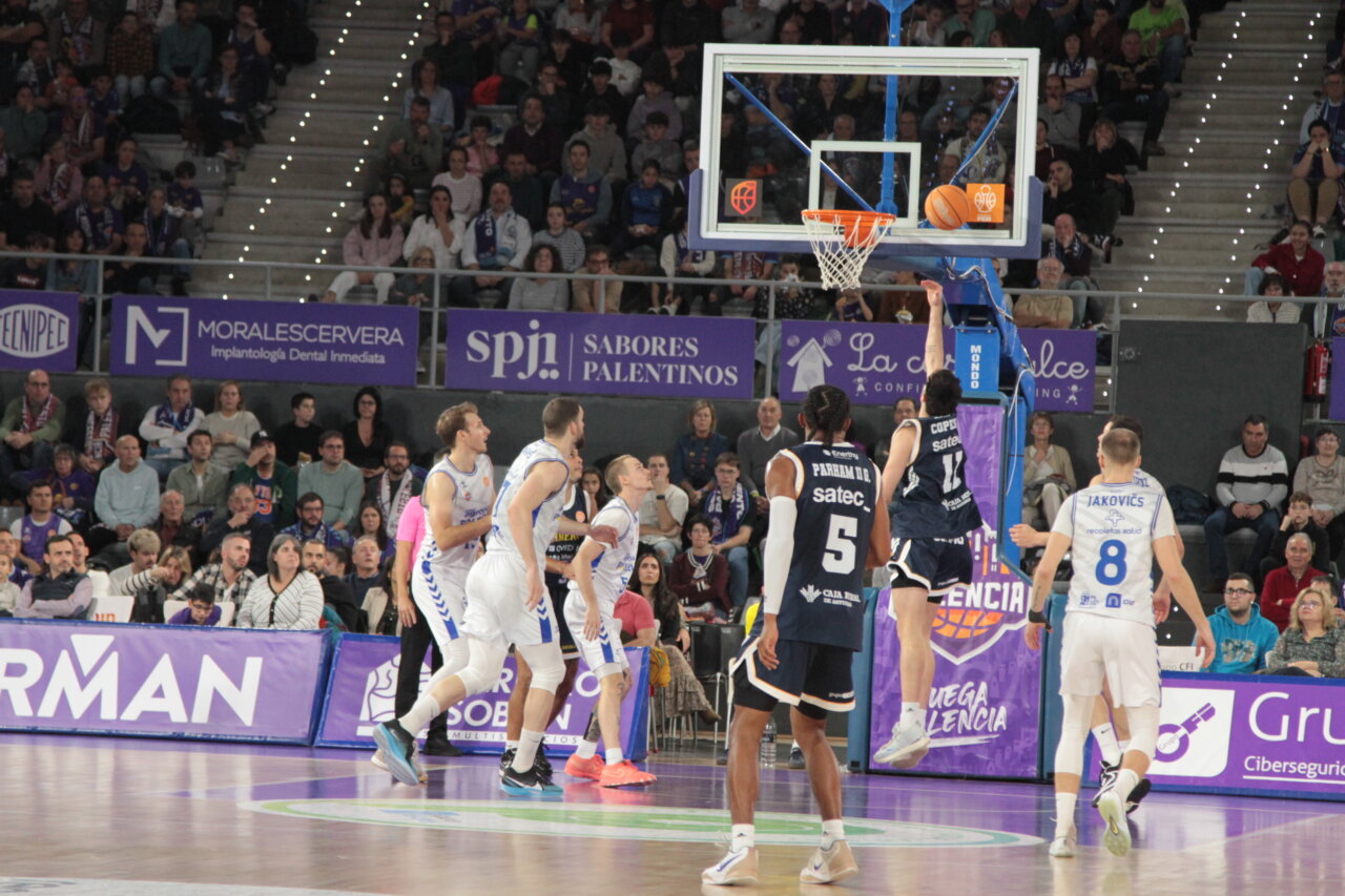 Jugadores de baloncesto en acción durante un partido entre Palencia y Oviedo.