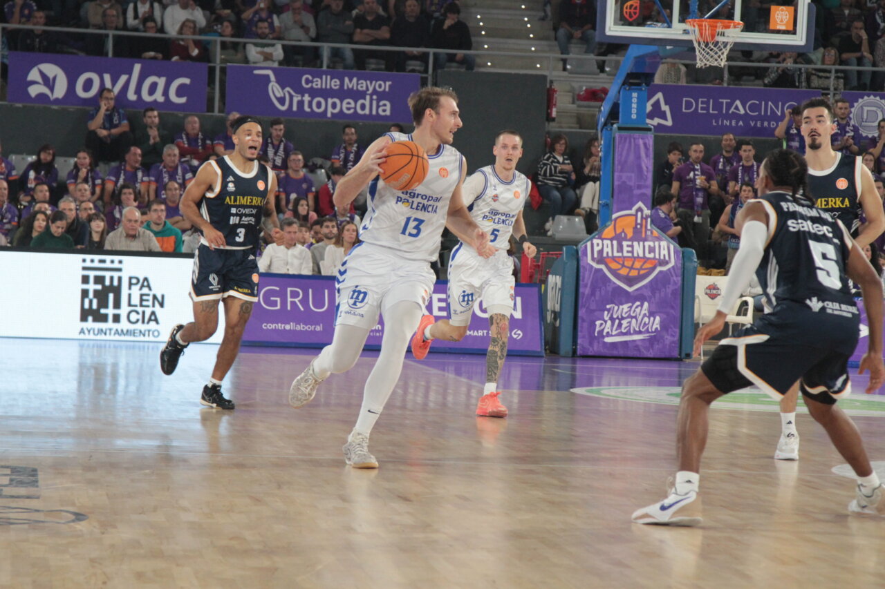 Jugador del Agropal Palencia avanzando con el balón en un partido de baloncesto.
