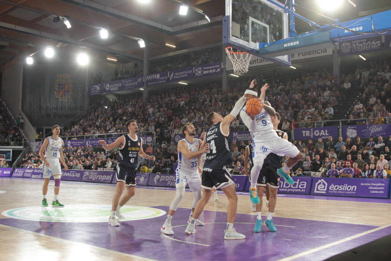 Jugadores de baloncesto en acción durante un partido entre Palencia y Oviedo.