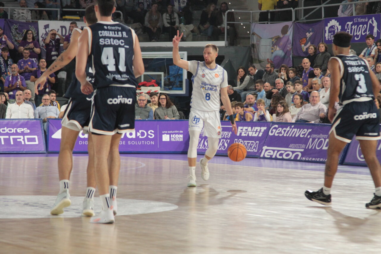 Jugadores de baloncesto en acción durante un partido entre Palencia y Oviedo.
