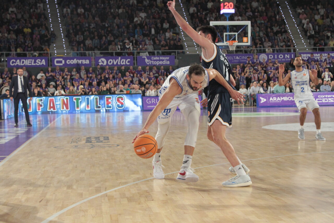 Jugadores de baloncesto compiten en un partido entre Palencia y Oviedo.