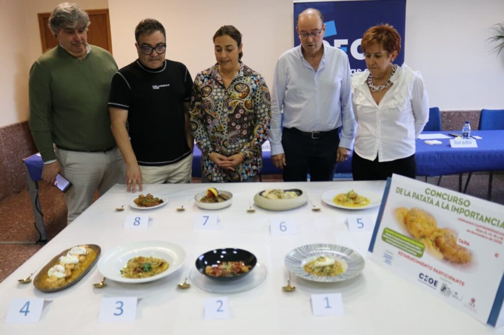 Participantes observando platos en el concurso de patatas a la importancia