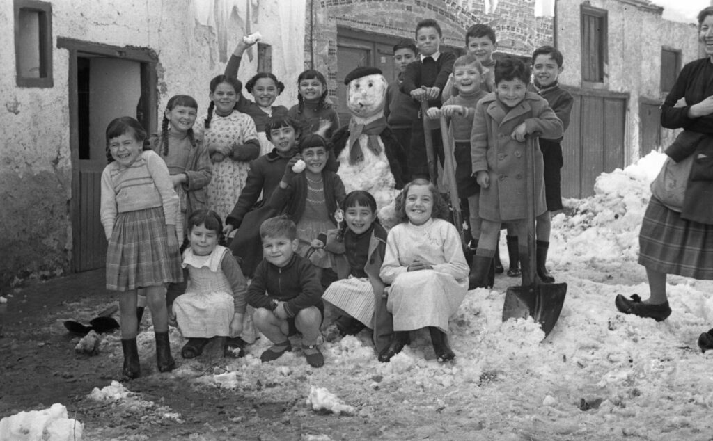 Grupo de niños posando con un muñeco de nieve en la Montaña Palentina