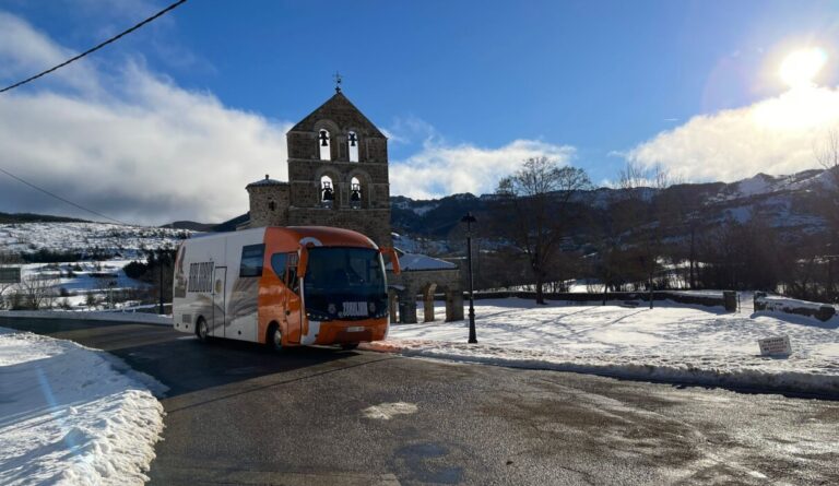 Bibliobús en un paisaje nevado con una iglesia al fondo