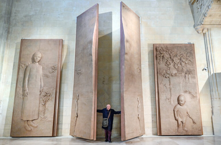 Esculturas de Antonio López en la Catedral de Palencia con un hombre de pie entre ellas.