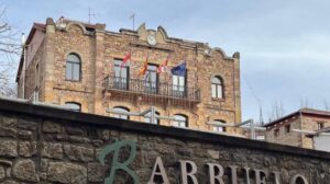 Vista del Ayuntamiento de Barruelo de Santullán con banderas ondeando.