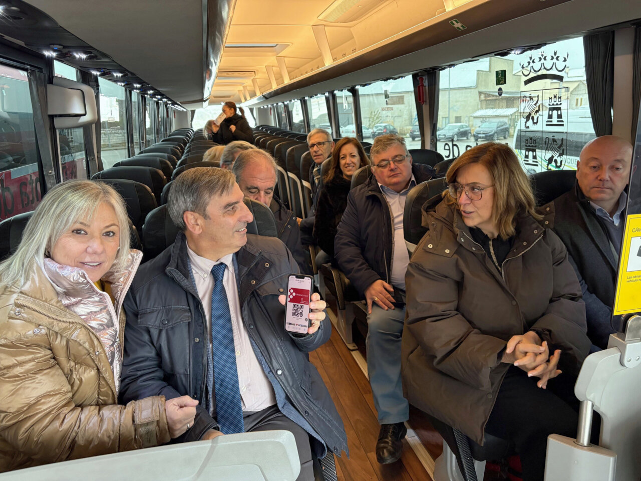 Grupo de personas en un autobús mostrando una tarjeta Buscyl