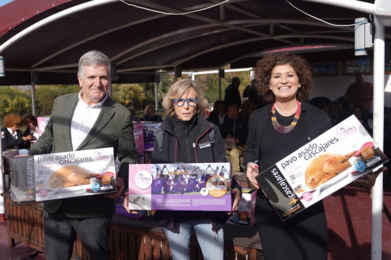 Tres personas sosteniendo cajas de pavo asado Cascajares en un evento