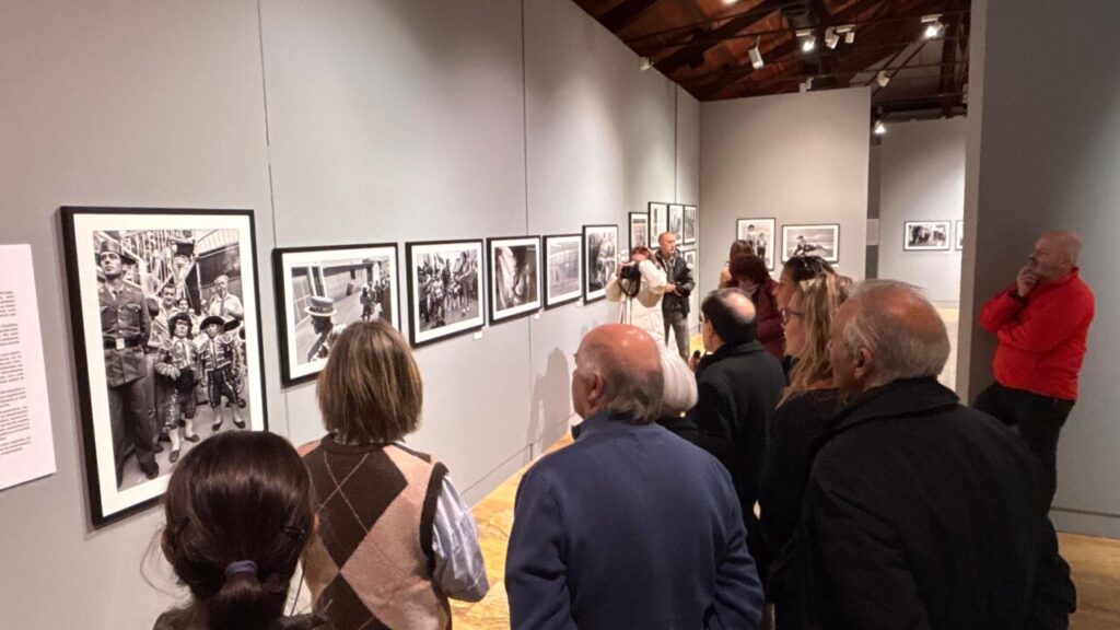 Visitantes observando fotografías en la exposición de Benito Román