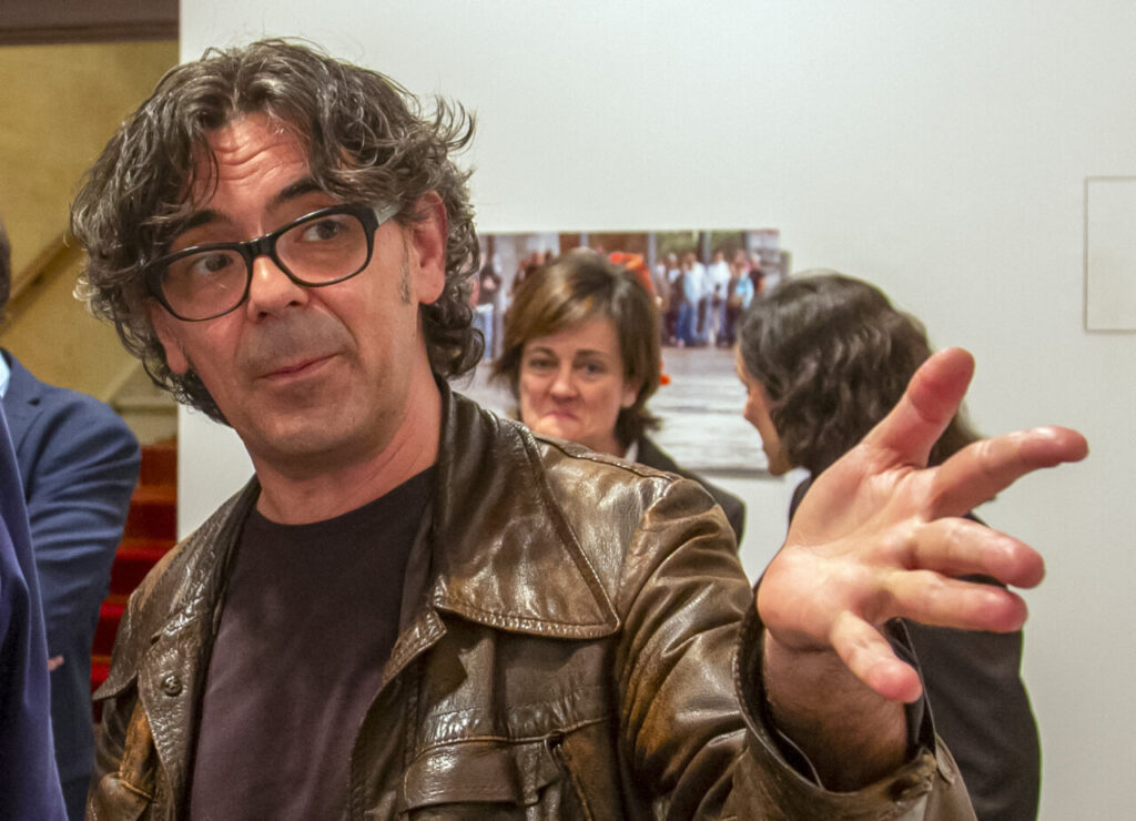 Claudio de la Cal en un evento con fondo de fotografías