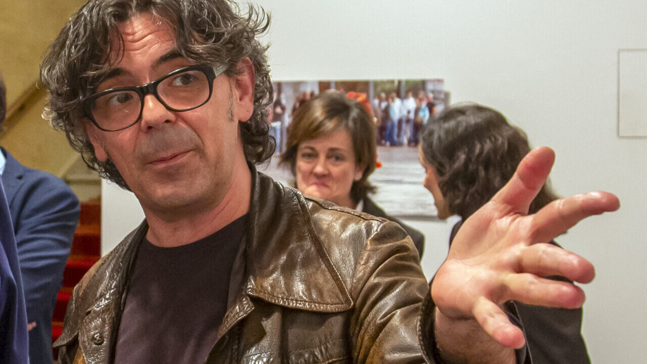 Claudio de la Cal en un evento con fondo de fotografías