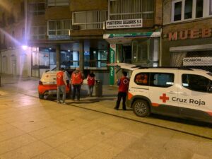 Voluntarios de Cruz Roja atendiendo a personas sin hogar en la calle.