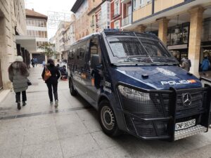 Furgón policial en una calle de Palencia con personas caminando
