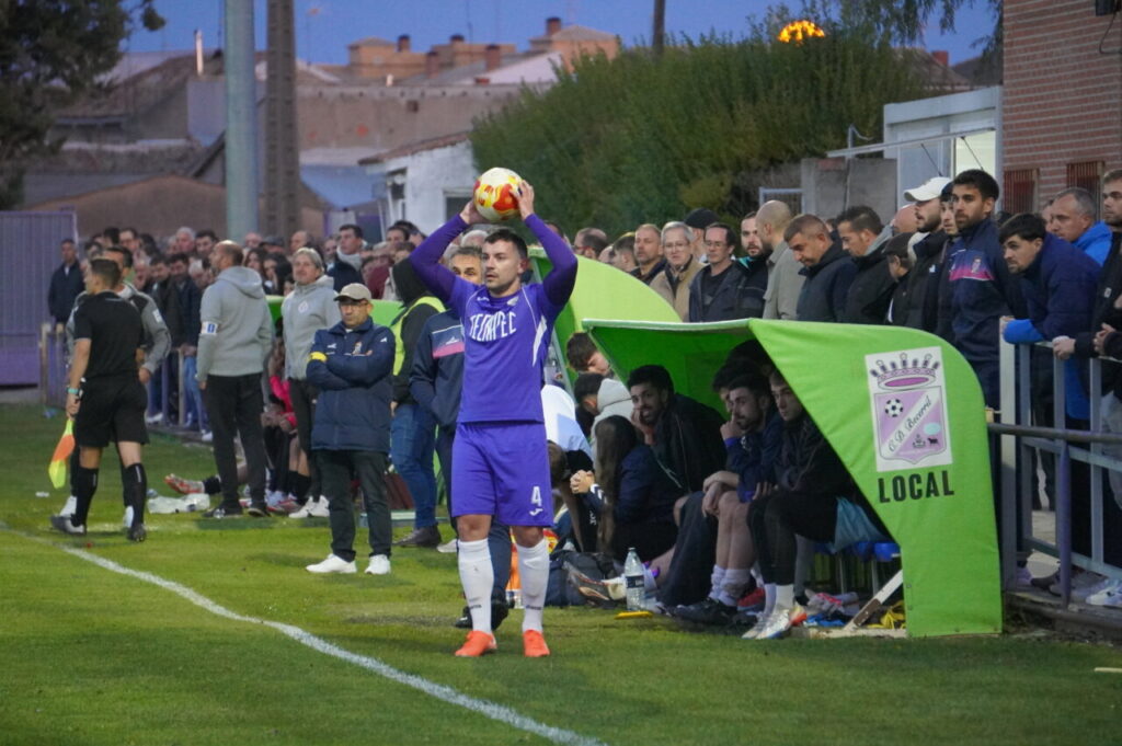 Jugador del Becerril realizando un saque de banda durante un partido de fútbol.