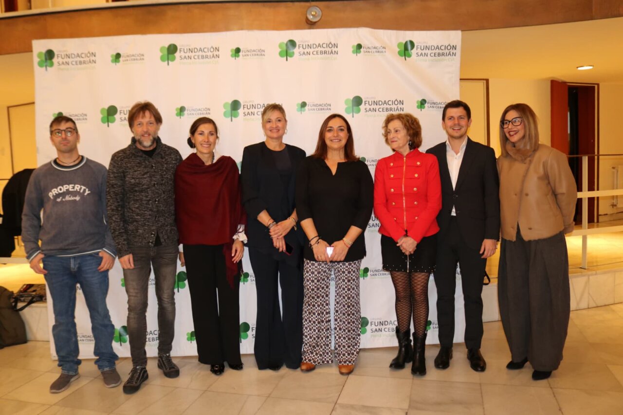Grupo de personas en evento de Fundación San Cebrián con fondo de marca BRIAN
