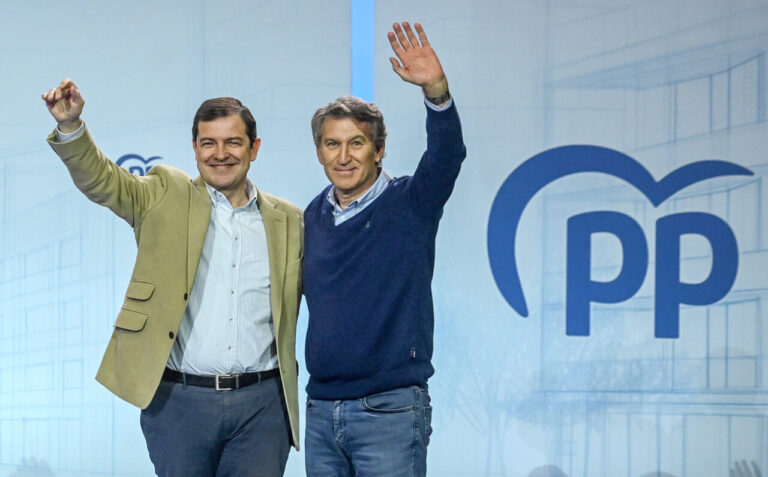 Líderes del PP en un evento político levantando la mano.