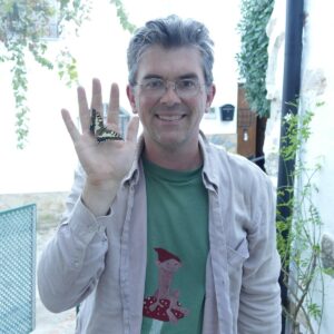 Florent Prunier sosteniendo una mariposa en su mano