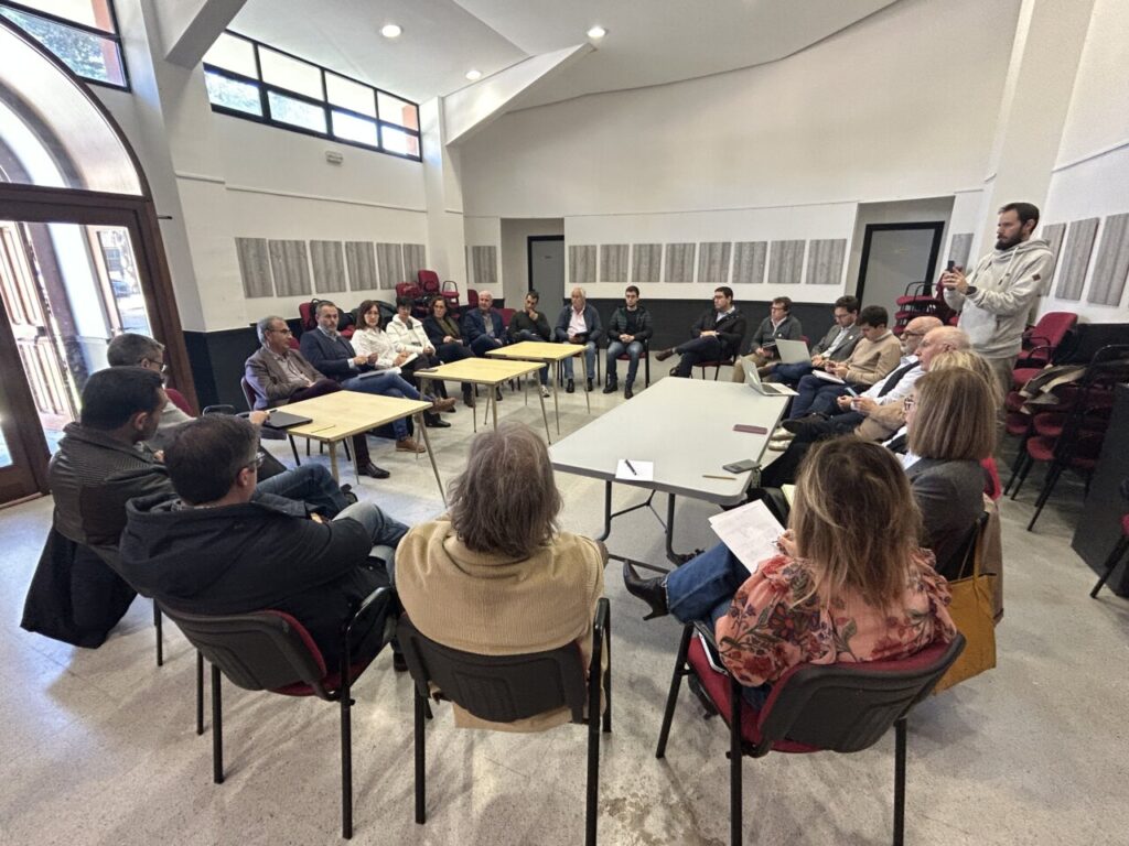Reunión de representantes municipalistas en un salón con mesas y sillas.
