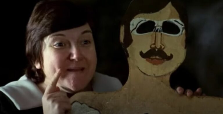 Escena de la película El espíritu de la colmena con un personaje mostrando una figura de madera.