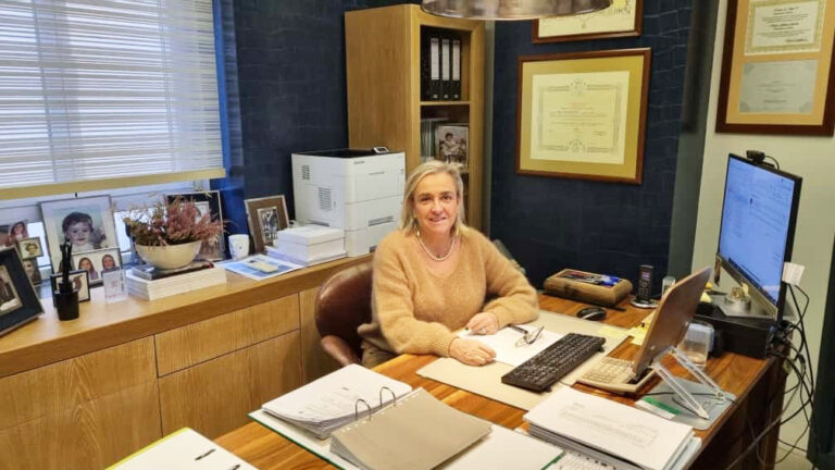 Mujer en oficina de Gestoría Gómez Arroyo trabajando en su escritorio.