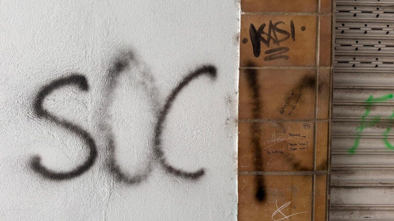 Grafiti en una pared con la palabra SOCIO escrita en negro