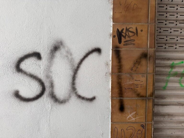 Grafiti en una pared con la palabra SOCIO escrita en negro
