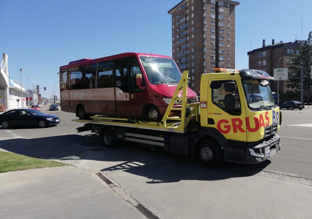 Camión de Grúas Brasil transportando un autobús en la calle