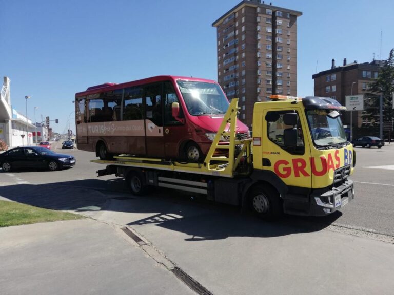 Camión de Grúas Brasil transportando un autobús en la calle