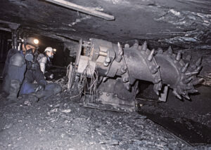 Trabajadores en una mina con maquinaria de extracción de carbón