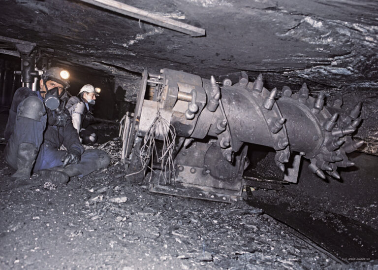 Trabajadores en una mina con maquinaria de extracción de carbón